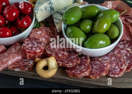 Nahaufnahme des Wurstbretts mit italienischem Fleisch, Oliven, Paprika, Crackern. Stockfoto