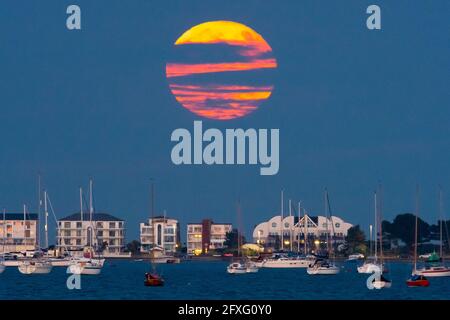 Poole, Dorset, Großbritannien. Mai 2021. Wetter in Großbritannien. Der Vollblumen-Supermond wird von Wolken verdeckt, als er aus der Reihe hinter Millionären bei Sandbanks bei Poole in Dorset aufsteigt. Bildnachweis: Graham Hunt/Alamy Live News Stockfoto