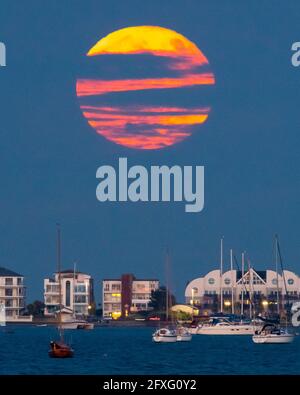 Poole, Dorset, Großbritannien. Mai 2021. Wetter in Großbritannien. Der Vollblumen-Supermond wird von Wolken verdeckt, als er aus der Reihe hinter Millionären bei Sandbanks bei Poole in Dorset aufsteigt. Bildnachweis: Graham Hunt/Alamy Live News Stockfoto