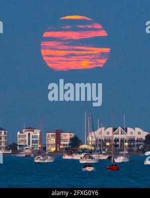 Poole, Dorset, Großbritannien. Mai 2021. Wetter in Großbritannien. Der Vollblumen-Supermond wird von Wolken verdeckt, als er aus der Reihe hinter Millionären bei Sandbanks bei Poole in Dorset aufsteigt. Bildnachweis: Graham Hunt/Alamy Live News Stockfoto