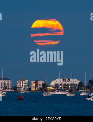 Poole, Dorset, Großbritannien. Mai 2021. Wetter in Großbritannien. Der Vollblumen-Supermond wird von Wolken verdeckt, als er aus der Reihe hinter Millionären bei Sandbanks bei Poole in Dorset aufsteigt. Bildnachweis: Graham Hunt/Alamy Live News Stockfoto