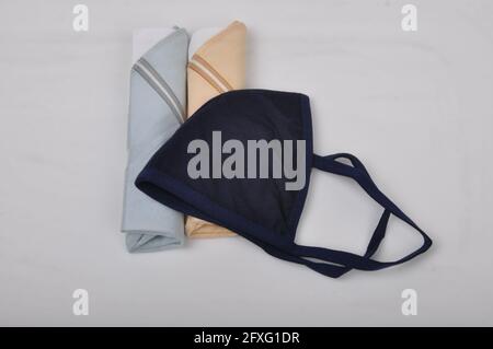 Nahaufnahme einer schwarzen Stoffmaske und Servietten auf einer weißen Oberfläche Stockfoto