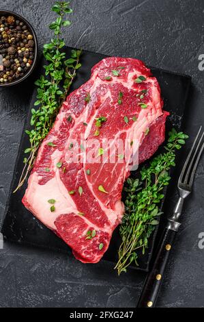 RAW Organic Chuck Eye Roll Fleisch Steak Schnitte. Schwarzer Hintergrund. Draufsicht Stockfoto