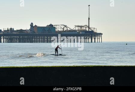 Brighton UK 27. Mai 2021 - ein Paddelboarder am frühen Morgen genießt die warme Sonne in Brighton mit einer heißeren, sonnigen Wetterprognose, die über das Feiertagswochenende in Großbritannien eintreffen wird, wobei die Temperaturen im Südosten voraussichtlich über 20 Grad erreichen werden: Credit Simon Dack / Alamy Live News Stockfoto