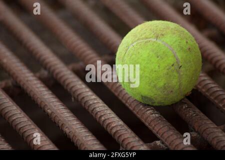 Gelber Tennisball auf roten Eisenstangen Stockfoto