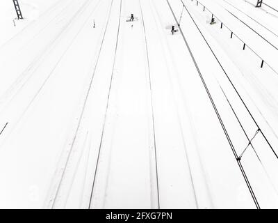 Blick über die schneebedeckten Eisenbahnschienen am Bahnhof nach Schneefall Am Wintertag Stockfoto