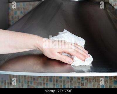 Weibliche Handtücher polierte Edelstahloberfläche der Küchenhaube Mit Serviette Nahaufnahme zu Hause Stockfoto