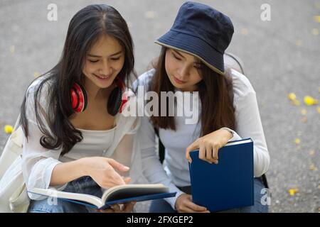 Nahaufnahme zweier junger Studentinnen Eine Idee, während Sie sich außerhalb des Klassenzimmers entspannen Stockfoto