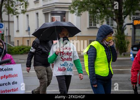 Demonstrat tragt Maske mit der Aufschrift: ' Merkel muss weg! ' und T-Shirt: ' Söder Merkel Spahn soll'n zur Hölle fahr'n '. Ca. 62 Corona Leugner*innen, Impfgegner*innen und Querdenken Aktivist*innen sammeln sich am 26.5.2021 in München, um gegen alle Corona Maßnahmen und für ein Ende des Lockdowns zu demontieren. - der Mann trägt eine Maske und liest: "Merkel muss gehen! ' und T-Shirt: ' Soeder, Merkel, Spahn müssen in die Hölle gehen '. Etwa 62 Covid-Leugner, Querdenker und NoVaxx-Aktivisten demonstrierten am 26. Mai 2021 gegen alle covid-Maßnahmen und für ein Ende Stockfoto