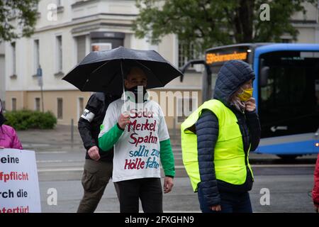 Demonstrat tragt Maske mit der Aufschrift: ' Merkel muss weg! ' und T-Shirt: ' Söder Merkel Spahn soll'n zur Hölle fahr'n '. Ca. 62 Corona Leugner*innen, Impfgegner*innen und Querdenken Aktivist*innen sammeln sich am 26.5.2021 in München, um gegen alle Corona Maßnahmen und für ein Ende des Lockdowns zu demontieren. - der Mann trägt eine Maske und liest: "Merkel muss gehen! ' und T-Shirt: ' Soeder, Merkel, Spahn müssen in die Hölle gehen '. Etwa 62 Covid-Leugner, Querdenker und NoVaxx-Aktivisten demonstrierten am 26. Mai 2021 gegen alle covid-Maßnahmen und für ein Ende Stockfoto