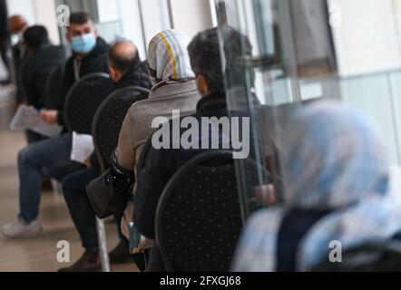 27. Mai 2021, Hessen, Frankfurt/Main: Männer und Frauen warten auf ihre Impfung im Kulturzentrum der Imam-Sadjad-Moschee im Landkreis Fechenheim, die von Afghanen aus dem Rhein-Main-Gebiet gegründet wurde. An drei aufeinander folgenden Tagen werden im Kulturzentrum täglich fast 200 Menschen von einem mobilen Impfteam des Maltesischen Hilfsdienstes geimpft. Die Impfkampagne in der Moschee ist Teil der Strategien der Stadt Frankfurt für eine hohe Impfrate. Foto: Arne Dedert/dpa/POOL/dpa Stockfoto