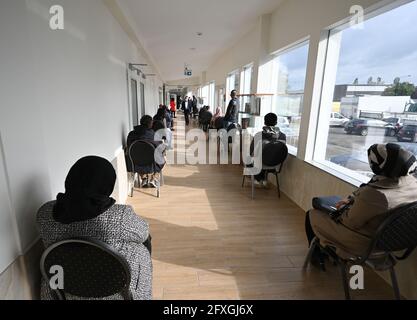 27. Mai 2021, Hessen, Frankfurt/Main: Männer und Frauen warten auf ihre Impfung im Kulturzentrum der Imam-Sadjad-Moschee im Landkreis Fechenheim, die von Afghanen aus dem Rhein-Main-Gebiet gegründet wurde. An drei aufeinander folgenden Tagen werden im Kulturzentrum täglich fast 200 Menschen von einem mobilen Impfteam des Maltesischen Hilfsdienstes geimpft. Die Impfkampagne in der Moschee ist Teil der Strategien der Stadt Frankfurt für eine hohe Impfrate. Foto: Arne Dedert/dpa/POOL/dpa Stockfoto