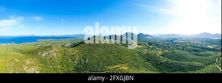 Blick von oben, atemberaubende Luftaufnahme eines Gebirges, bedeckt von einer grünen Vegetation mit einer wunderschönen Küste, die vom mittelmeer umspült wird. Stockfoto