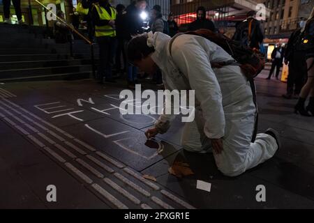 Melbourne, Australien 27. Mai 2021, schreibt ein Protestler während einer Schnellkundgebung von Anti-Lockdown-Demonstranten vor der Flinders Street Station in Melbourne auf dem Fußweg, wo Demonstranten ihre Meinung zur 7-tägigen Sperre äußern, die heute Abend um Mitternacht beginnen soll. Kredit: Michael Currie/Alamy Live Nachrichten Stockfoto