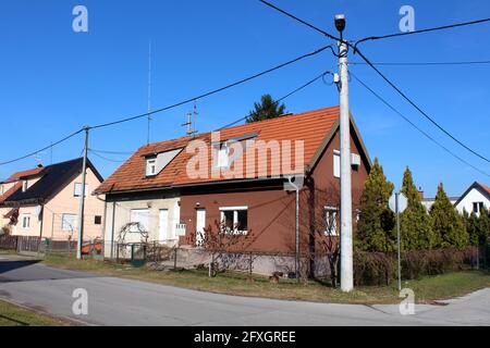 Halb renovierte kleine angeschlossene Vorstadtstraße Ecke Familienhaus mit zwei Eingängen und mehrere Fenster mit Drahtzaun und anderen Häusern umgeben Stockfoto