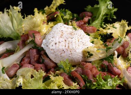 Rezept für pochiertes Ei, das mit einem Messer, Speck und Salat geschnitten wurde Stockfoto