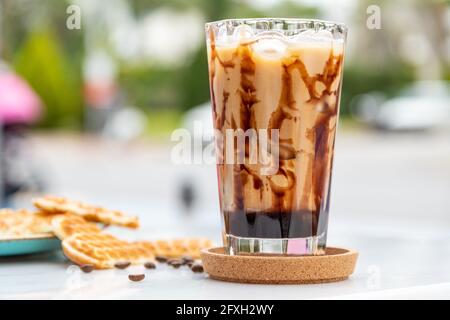 Iced Caramel Latte Kaffee in einem hohen Glas mit Karamell Sirup Stockfoto