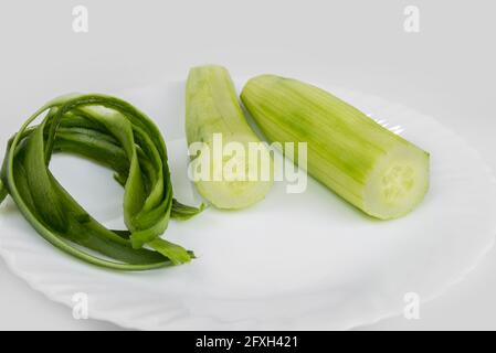 Gurken und Schälchen auf weißem Hintergrund abschälen Stockfoto