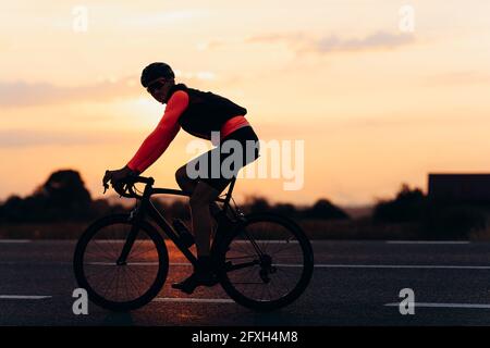 Hübscher junger Radfahrer, der im Freien auf der Straße radeln kann Stockfoto