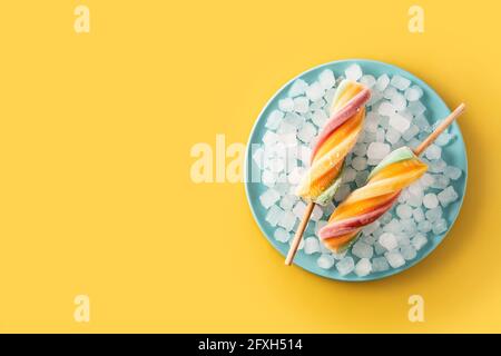 Spiral bunten Eis mit Früchten auf gelow Hintergrund Stockfoto