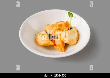 Gebratene Kuchen auf einem weißen Teller auf grauem Hintergrund. Russische Teezeit. Vorderansicht. Stockfoto