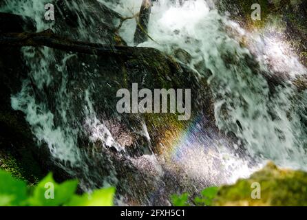 Abstraktes Bild von fallendem Wasser in der Natur mit Schaum und Spritz- und Sonneneinstrahlung Stockfoto