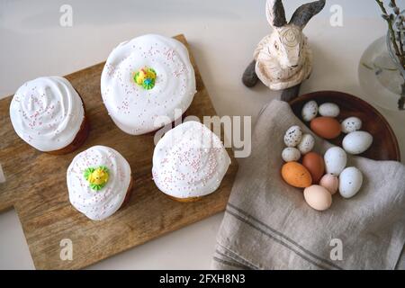 Vorbereitung auf Holly Urlaub. Waist-up-Porträt der glücklichen Familie zeigt gerade gebackenen leckeren Osterkuchen mit Belag auf ihr weibliches Kind Stockfoto