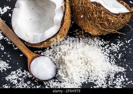 Frische Kokosnuss und Kokosöl auf Holzlöffel Stockfoto
