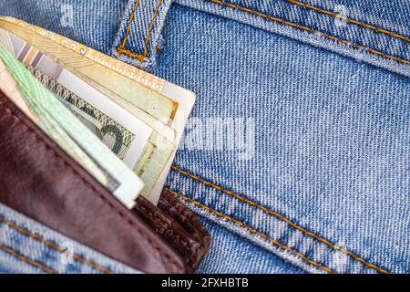 Brieftasche und viele polnische Banknoten ragen aus der Gesäßtasche der Denim-Hose. Foto aufgenommen unter künstlichem, weichem Licht Stockfoto