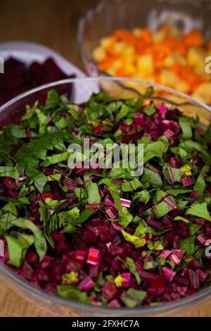 Frische, gehackte Rote-Bete-Blätter in einer Glasschüssel angeordnet. Foto aufgenommen unter künstlichem, weichem Licht. Stockfoto