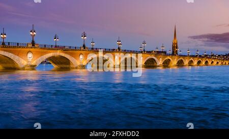 GIRONDE(33), BORDEAUX, STEINBRÜCKE MIT BLICK AUF DIE ST. MICHAEL'S KIRCHE ZUR BLAUEN STUNDE Stockfoto