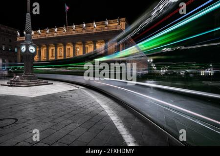 FRANKREICH. GIRONDE (33), BORDEAUX, PLACE DU GRAND THEATER, NET EINER STRASSENBAHN, DIE VOR DEM GROSSEN THEATER UND SEINER UHR VORBEIFÄHRT Stockfoto