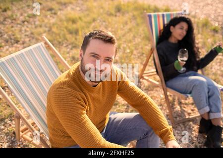 Portrait selbstbewusster Mann, der sich in einem Rasenstuhl von einer Freundin entspannt Stockfoto