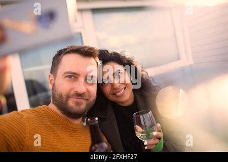 Glückliches Paar, das Selfie auf der Terrasse macht Stockfoto