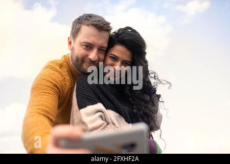 Glückliches, liebevolles Paar in Pullovern, die Selfie machen Stockfoto