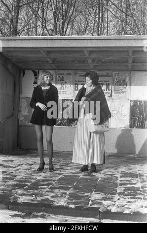 Frau im Volendam-Kostüm und Mädchen im Minirock an einer Bushaltestelle in Volendam an einem autofreien Sonntag, dem 2. Dezember 1973, autofreien Sonntagen, Kostümen, Mädchen, Frauen, Niederlande, 20. Jahrhundert Presseagentur Foto, Nachrichten zu erinnern, Dokumentarfilm, historische Fotografie 1945-1990, visuelle Geschichten, Menschliche Geschichte des zwanzigsten Jahrhunderts, Momente in der Zeit festzuhalten Stockfoto