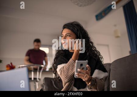 Schöne Frau mit Smartphone zu Hause Stockfoto