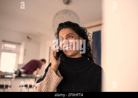 Glückliche Frau sprechen über Smart Phone zu Hause Stockfoto