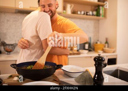 Glücklich Gay männliche paar Umarmung und Kochen in Küche Stockfoto