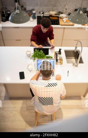 Schwule männliche Paar arbeitet von zu Hause aus am Laptop und digitalen Tablet Stockfoto