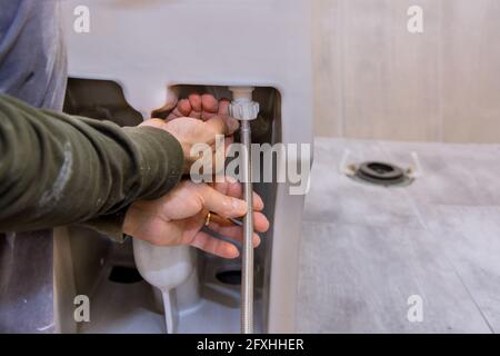 Ein Badezimmer Umbau Projekt Installation einer neuen weißen Toilettenschüssel. Unvollendete Innenraum der Renovierung Bad Stockfoto