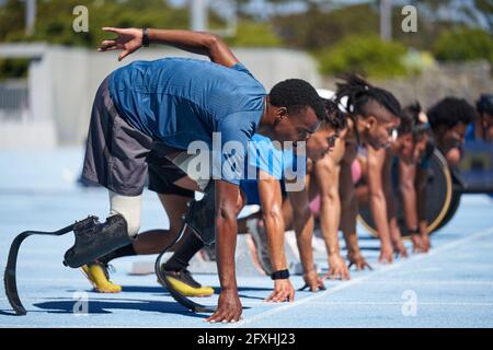Amputierte Sprinter bereit an der Startlinie auf der sonnigen Sportstrecke Stockfoto