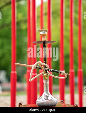 Der Kopf einer Shisha, Wasserpfeife oder Shisha mit glühender Kohle im Garten im Sommersonnenschein Deutschland, Kopf, Wasserpfeife, Rauchen, Arabeske Stockfoto