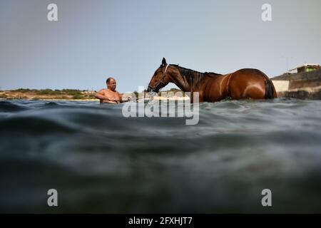 Bahar Ic Caghaq. Mai 2021. Ein Rennpferd wird am 26. Mai 2021 in der Stadt Bahar IC-Caghaq, Malta, zum Schwimmen im Meer trainiert. Quelle: Jonathan Borg/Xinhua/Alamy Live News Stockfoto