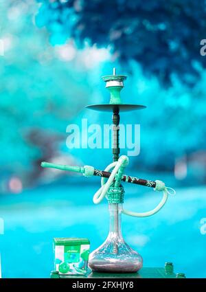 Der Kopf einer Shisha, Wasserpfeife oder Shisha mit glühender Kohle im Garten im Sommersonnenschein Deutschland, Kopf, Wasserpfeife, Rauchen, Arabeske Stockfoto