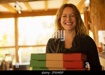 Portrait glückliche weibliche Pizzeria-Besitzerin mit Pizzaboxen Stockfoto