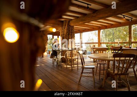Nachdenkliche kleine Geschäftsbesitzerin, die im Café arbeitet Stockfoto