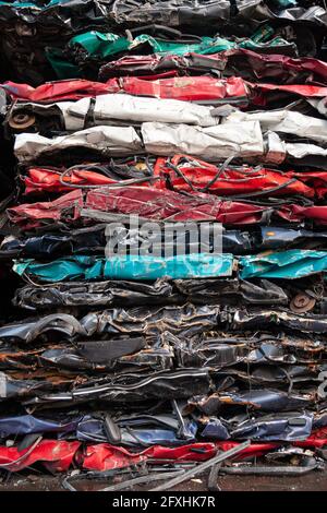 Stapel von gepressten Fahrzeugen in verschiedenen Farben aus einem Auto-Recycling-Zentrum. Stockfoto