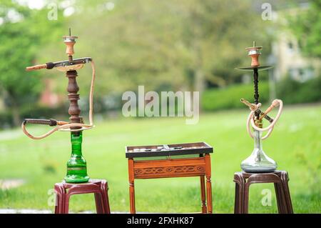 Der Kopf einer Shisha, Wasserpfeife oder Shisha mit glühender Kohle im Garten im Sommersonnenschein Deutschland, Kopf, Wasserpfeife, Rauchen, Arabeske Stockfoto