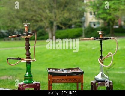 Der Kopf einer Shisha, Wasserpfeife oder Shisha mit glühender Kohle im Garten im Sommersonnenschein Deutschland, Kopf, Wasserpfeife, Rauchen, Arabeske Stockfoto
